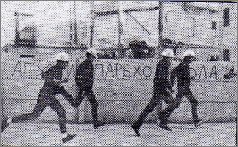 Miembros del colectivo APS corriendo por la calle ante una pintada