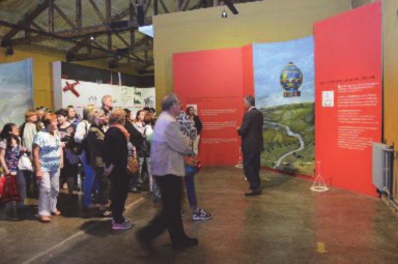 Grupo de visitantes escuchando al guía. Predominio de adultos y adultos mayores. Imagen facilitada por el encargado del Museo Tecnológico Aeroespacial, Sr. José Luis Araya. Tomadas por el fotógrafo del Área de Materiales Río Cuarto, Sr. Darío Merelles.