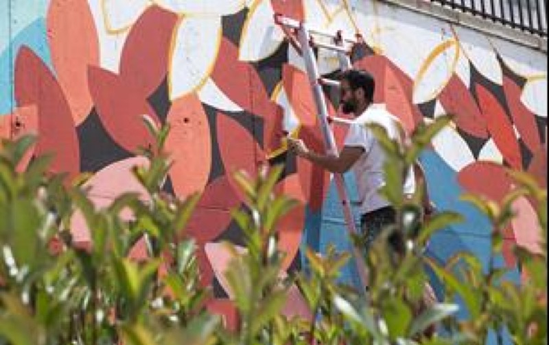 Pablo Purón, del colectivo Boa Mistura, ilustrando el muro con motivos vegetales