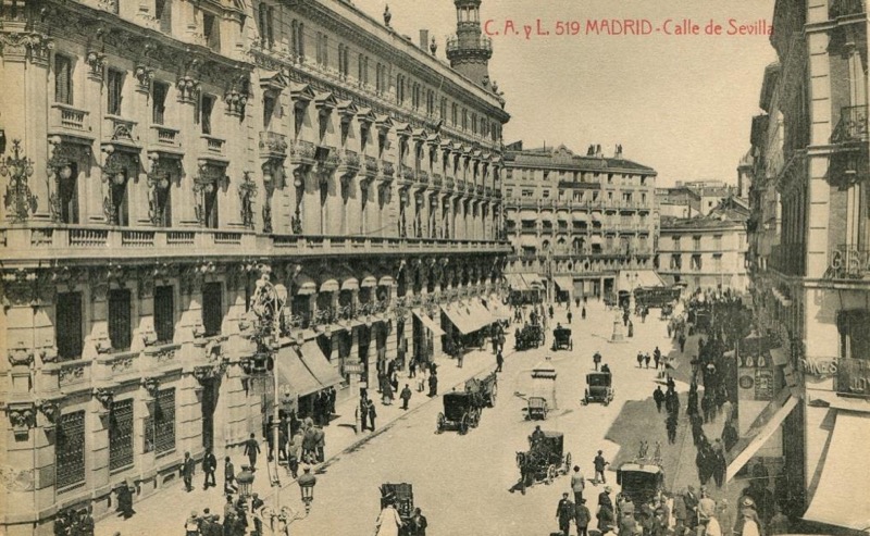 Vista parcial de la calle de Sevilla y al fondo se aprecia la calle de Alcalá y el edificio del café de Fornos (con toldo), angular con la calle de los Peligros, hacia 1920.