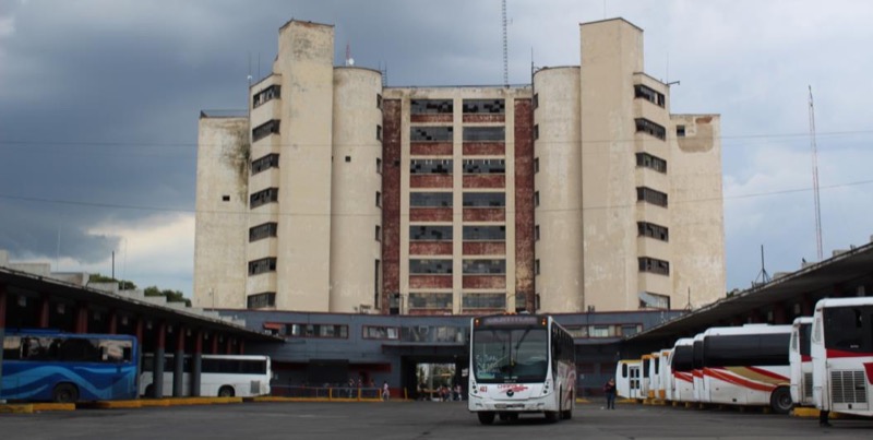 Vista de la fachada posterior de los edificios y los andenes, destaca la volumetría y materialidad de la torre.